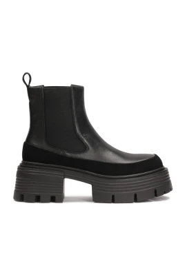 Svarta chelsea-boots på en upphöjd sula med prägling