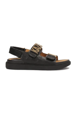 Sandaler dekorerade med metallbokstäver och prägling