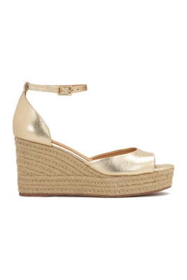 Guld sandaler på ankare täckt med jute snöre