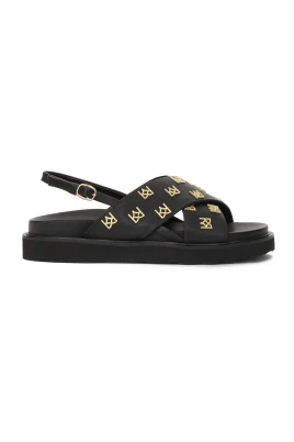Platta sandaler dekorerade med metallmonogram