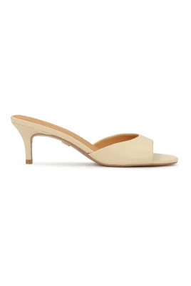 Kräm flip-flops på en låg stilettklack