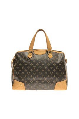 Vrouw met zwart Louis Vuitton tas met gouden logo en bruine jas