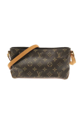 Vrouw met zwart Louis Vuitton tas met gouden logo en bruine jas